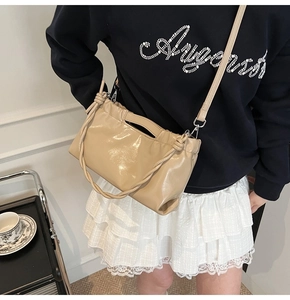 Close-up of khaki PU leather drawstring handbag with woven handle and pleated details