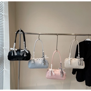Detail showing various colors of Boston shoulder bags with lace bows and pearl charms