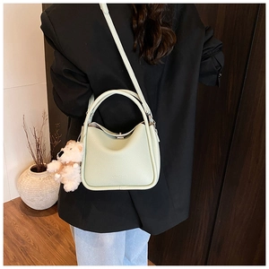 Vue détaillée du sac en cuir vert clair avec charmant petit ours en peluche blanc