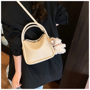 Détail du sac à main en cuir grainé blanc crème avec charmant pendentif ours peluche
