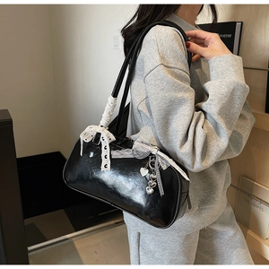 Detail of black glossy bowling shoulder bag with white lace bow and heart charms