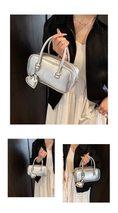 Detail of silver metallic bowling bag with double handles and heart pendant