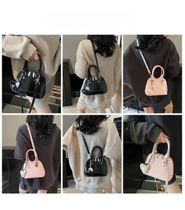 Mini shell bags in black and pink with heart charms shown on models for versatile styling