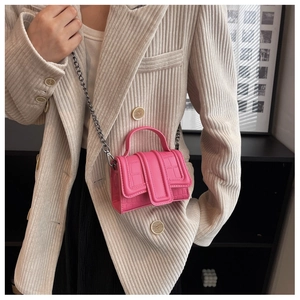 Vue détaillée d'un mini sac à main rose effet croco avec bandoulière chaîne sur modèle