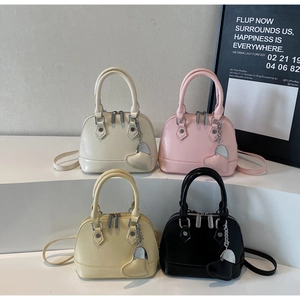 Mini shell bags in cream, pink, yellow, and black colors with heart charms on stands