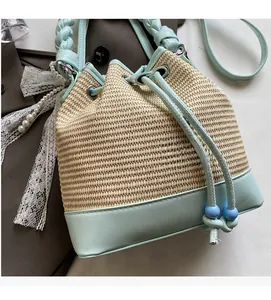 Detail of woven straw bucket bag with blue leather trim and drawstring closure