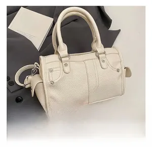Dettaglio della borsa in pelle granulata bianco crema con cuciture e rivetti in metallo