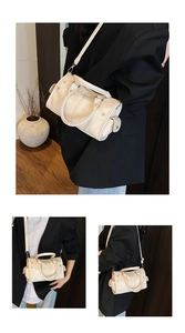 Detailed macro view of cream-colored lychee textured leather and Boston bag stitching