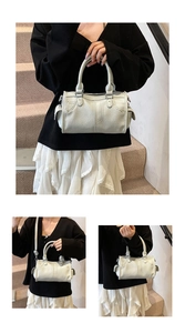 Detailed view of white lychee pattern Boston bag with top handles and shoulder strap.