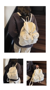 Vue détaillée du sac à dos en toile blanche avec poches frontales doubles et boucles en métal