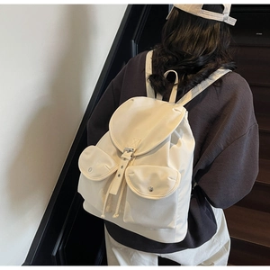 Mannequin portant un sac à dos crème minimaliste avec double poches et rabat à cordon