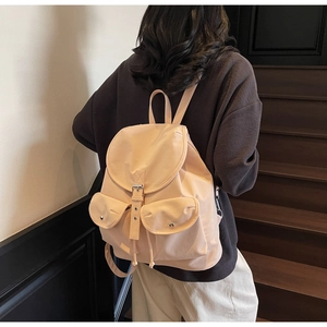 Vue détaillée du sac à dos rétro kaki avec deux poches frontales et fermeture à rabat
