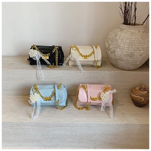 Detail of four colorful square chain bags on stone steps with decorative dried flowers