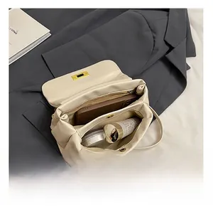 Detail of the cream square shoulder bag showing spacious interior with zipper pocket