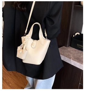 Detail of off-white lychee texture leather bucket bag with handle and shoulder strap