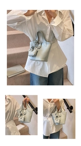 Detail of light blue lychee pattern leather bucket bag with a mini pouch on stairs