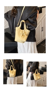 Detail of light yellow lychee textured leather bucket bag with matching mini pouch charm