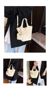 Detail view of cream lychee texture bucket bag with mini charm and adjustable strap