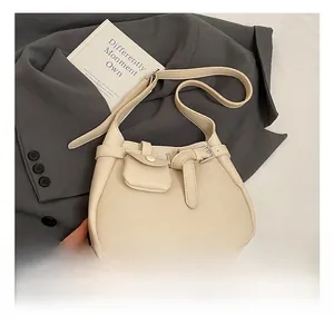 Detail of off-white lychee texture leather bucket bag with a mini coin purse attachment