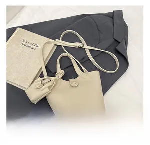 Detail of cream lychee texture leather bucket bag with matching mini coin purse pouch