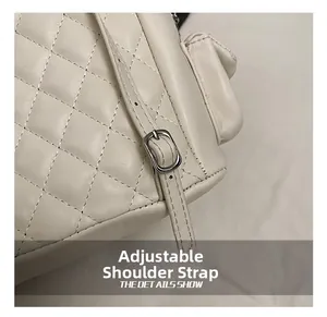 Close-up of beige quilted backpack showing adjustable strap and silver metal buckle