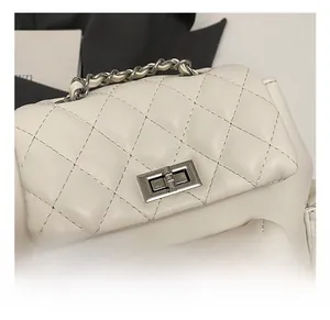 Close-up of silver metal twist lock and quilted leather texture on white backpack