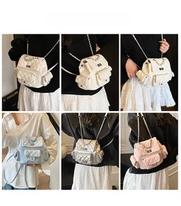 Quilted backpack with silver chain straps and multiple functional pockets shown on a model