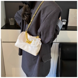 Detail of white leather shoulder bag with gold chain strap and lace pearl pendant