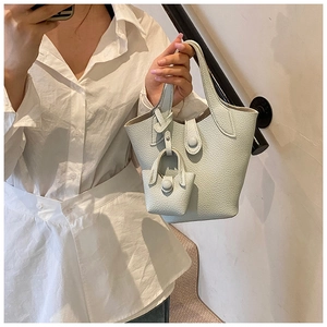Close-up of mint green bucket bag featuring lychee grain leather and mini pouch