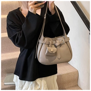 Taupe bucket bag detail with lychee grain texture and mini flap coin purse attachment