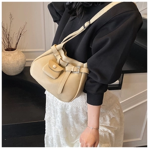 Detail of beige bucket bag with lychee texture synthetic leather and buckle strap