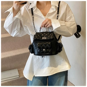 Detail of quilted mini backpack with silver metal twist lock and chain strap