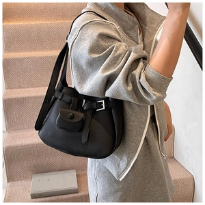 Close-up of black leather shoulder bag with multi-pockets and decorative belt buckle