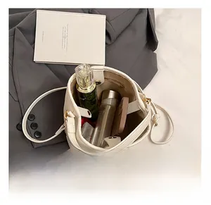 Top view of the spacious white litchi leather bucket bag interior with daily essentials