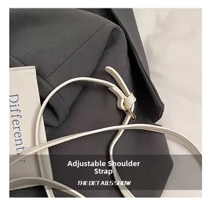 Detail of adjustable white leather shoulder strap with high-quality gold metal buckle