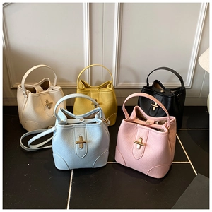Detail of five colorful bucket bags featuring cross-lock metal closures and lychee grain texture