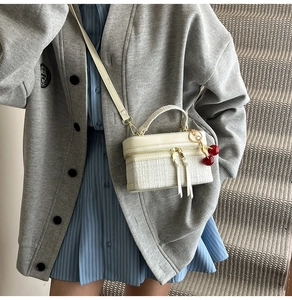White tweed small crossbody bag featuring a cherry charm and elegant leather top handle
