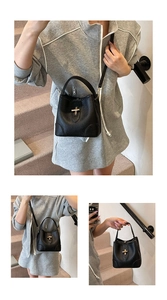 Detail of black pebbled leather bucket bag with gold turn-lock and adjustable strap