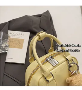 Dettaglio dei manici della borsa gialla e della chiusura sicura con doppia zip