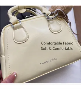 Dettaglio della borsa bowling crema con pelle morbida e logo alla moda
