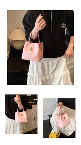 Detailed shot of pale pink lychee pattern leather bucket bag with gold cross twist lock