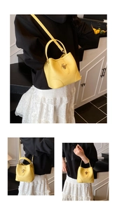 Detailed macro view of lemon yellow bucket bag with lychee texture and gold twist lock