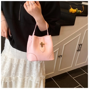 Detail of pink bucket bag featuring litchi grain leather and a gold twist lock closure