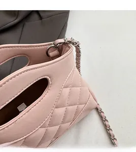 Dettaglio borsa in pelle trapuntata rosa con catena in metallo e cuciture rifinite