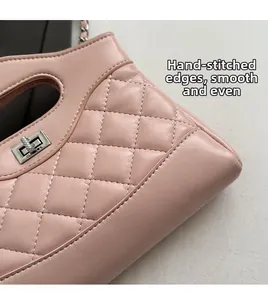 Dettaglio di borsa in pelle rosa trapuntata con chiusura girevole e cuciture a mano