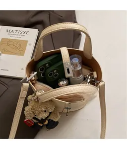 Top view of beige bucket bag showing interior space with two phones and cosmetics