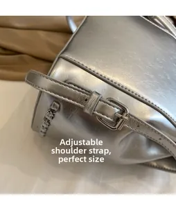 Macro detail of silver metallic cracked texture bag with adjustable shoulder strap and buckle