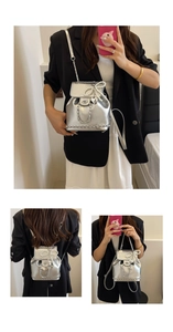 Detail of silver metallic mini backpack with pearl bow and heart charm on flap