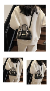 Close-up of black lychee grain leather mini bag with gold hardware and silk scarf detail