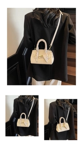 Detail of cream mini handbag with lychee texture, metal lock, and scarf-wrapped handle